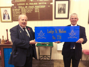 Brother Jim Coles presents RWM Tim Keen with the new sign for the outside of the Lodge building